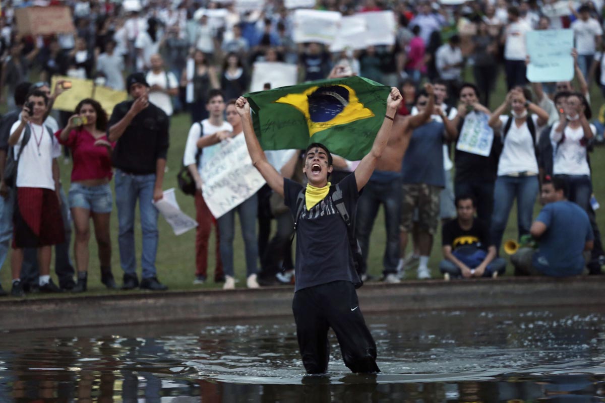 A demonstrator with the Brazilian flag protests against the Confederation's Cup and the government of Brazil's President Dilma Rousseff in Brasilia June 17, 2013. Tens of thousands of demonstrators marched through the streets of Brazil's biggest cities on Monday in a growing protest that is tapping into widespread anger at poor public services, police violence and government corruption. Protesters are using the Confederation's Cup as a counterpoint to amplify their concerns. REUTERS/Ueslei Marcelino (BRAZIL - Tags: POLITICS SPORT SOCCER CIVIL UNREST) ORG XMIT: UMS053